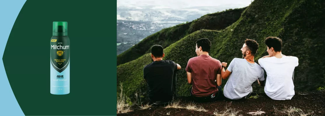 Mitchum deodorant spray bottle with four people sitting on a hillside