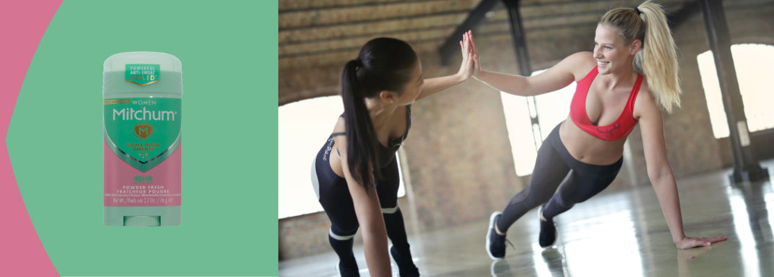 Two women exercising in a studio with a Mitchum deodorant container on a green background